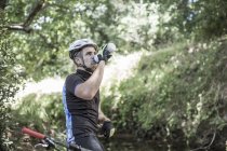 Людина на гірських в лісі питної води — стокове фото
