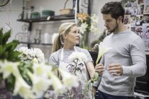 Verkäuferin im Blumenladen berät Kunden — Stockfoto