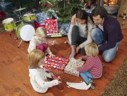Family unwrapping Christmas presents, overhead view — Stock Photo