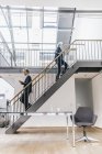 Бізнес-леді і бізнесмен ходіння по сходах в лофт — стокове фото
