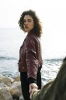 Retrato de jovem mulher na frente do mar segurando mão de amigo — Fotografia de Stock