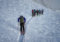 Skiers with backpacks hiking on track in mountains — Stock Photo