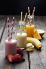 Bottiglie con frullati di frutta colorati — Foto stock