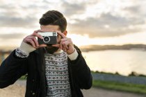 Bearded man with an old camera taking a picture of viewer — Stock Photo