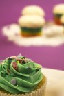 Topping of cupcake with green cream and baking dekor, close-up — Stock Photo
