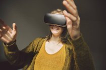 Donna che indossa occhiali di realtà virtuale con le mani — Foto stock