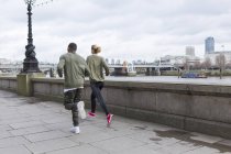 Uk, london, mann und frau rennen am fluss — Stockfoto
