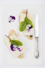 Оливковый багет с альпийским сыром, фиолетовым и кровавым доком, съедобные цветы — стоковое фото
