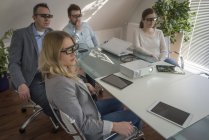Четыре коллеги с 3D очками на презентации с проектором в конференц-зале — стоковое фото