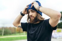 Retrato del joven barbudo poniéndose su sombrero lanudo - foto de stock
