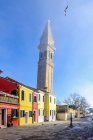 Vue sur tour inclinée et rangée colorée de maisons au soleil, Burano, Veneto, Italie — Photo de stock