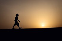 Silhouette dell'uomo che cammina sulle dune — Foto stock