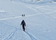 Italy, Gran Paradiso, skiers hiking in snow covered mountains — Stock Photo