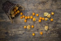 Physalis in basket and on wooden surface — Stock Photo