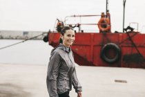 Donna con cuffie che cammina al porto — Foto stock