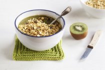 Tazón de batido verde con mezcla de copos de avena y granola - foto de stock