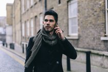 Junger Mann läuft mit Handy auf der Straße — Stockfoto