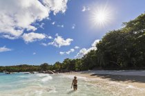 Seychellen, praslin, anse lazio, strand, weibliche touristin im wasser — Stockfoto