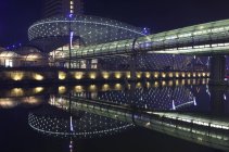 Germany, Bremerhaven, Klimahaus at night over water — Stock Photo