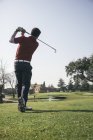 Golfista batendo uma bola em um campo de golfe — Fotografia de Stock