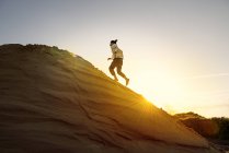 Man running uphill in desert — Stock Photo