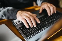 Mãos de homem sênior usando laptop — Fotografia de Stock
