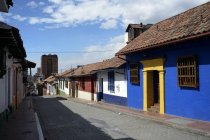 Colombia, Bogotá, La Candelaria, Casco antiguo, hilera de casas contra calle - foto de stock