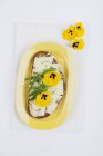 Slice of bread garnished with Pecorino cheese, rocket and pansies — Stock Photo