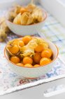 Closeup view of colorful physalis in bowls on tray — Stock Photo