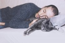 Russische blaue Katze und Besitzer schlafen auf der Couch — Stockfoto