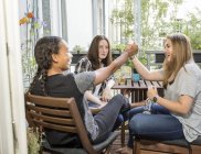 Три щасливі дівчат-підлітків сидячи на балконі — стокове фото