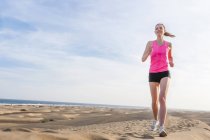 Giovane donna che corre sulla spiaggia — Foto stock