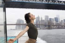 EUA, Nova York, jovem mulher de pé em um barco de excursão em um dia ventoso — Fotografia de Stock