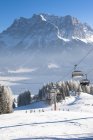 Austria, Tirolo, Lermoos, seggiovia nel paesaggio invernale con vista su Zugspitze — Foto stock