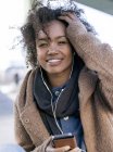 Portrait of smiling young woman  hearing music with earphones — Stock Photo