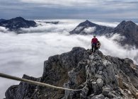 Groenlandia, Kulusuk, Los montañeros en la cumbre en los nublados Alpes de Schweizerland - foto de stock
