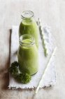 Two glass bottles of kale smoothie — Stock Photo