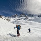 Italy, Gran Paradiso, skiers hiking in snow covered mountains — Stock Photo