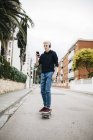 Giovane con le cuffie sullo skateboard — Foto stock