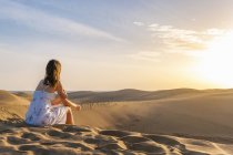 Donna seduta sulle dune — Foto stock