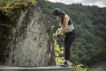Germany, Westerwald, Hoelderstein, woman climbing on via ferrata — Stock Photo