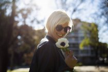 Блондинка жінка проведення квітка — стокове фото