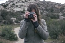 Donna che scatta una foto con una fotocamera analogica — Foto stock