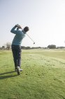 Golfista batendo uma bola de golfe em um campo de golfe — Fotografia de Stock