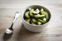 Closeup view of cucumber salad in bowl with spoon — Stock Photo