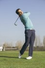 Golfista batendo uma bola de golfe em um campo de golfe — Fotografia de Stock