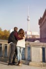 Germany, Berlin, young couple at River Spree looking at TV tower — Stock Photo