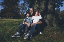 Padre y sus hijos sentados en un árbol - foto de stock