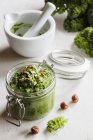 Preserving jar of vegan kale pesto with hazelnuts — Stock Photo