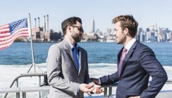 Zwei Geschäftsleute im Gespräch auf der Fähre auf dem East River, New York City, USA — Stockfoto